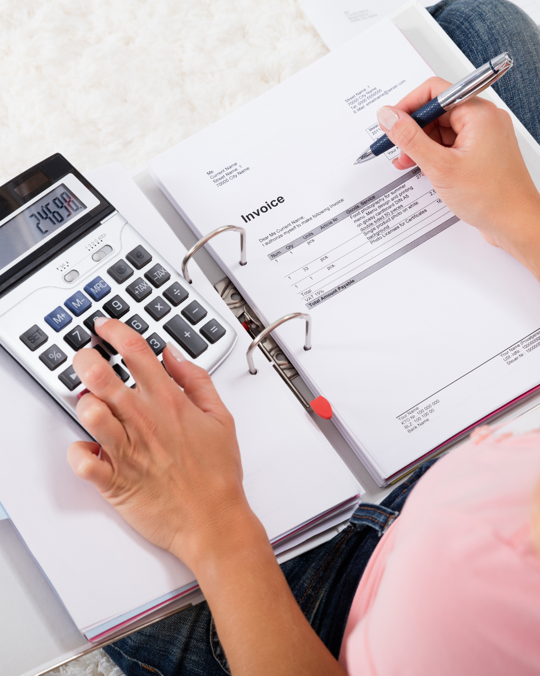 Henkilö tekemässä ensimmäistä kuukausibudjettia muistikirjaan keittiön pöydän ääressä.