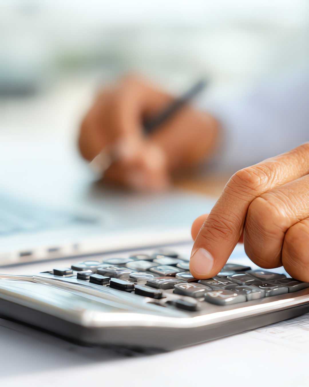 Henkilö tarkastelemassa tiliotetta ja merkitsemässä budjetin kiinteitä ja muuttuvia kuluja.